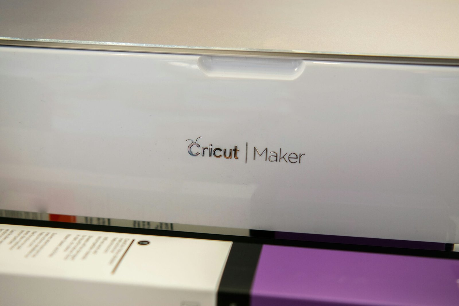 Cricut Maker in Action A Cricut Maker machine loads a cutting mat with a purple sheet inside.
