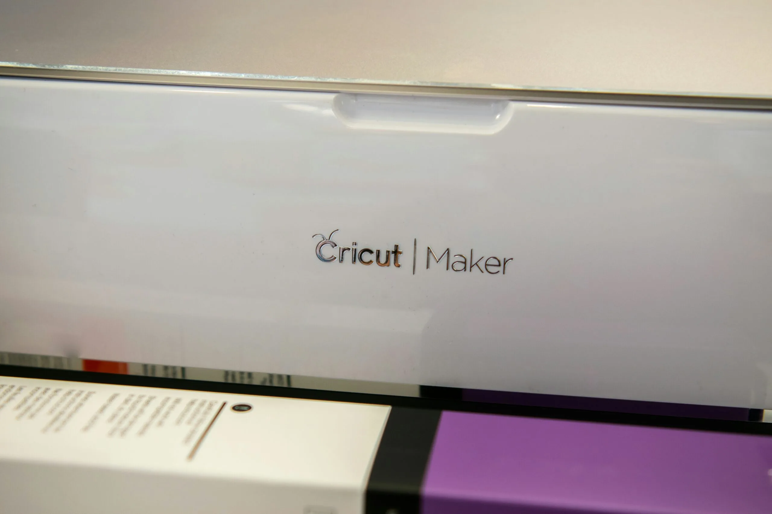 Cricut Maker in Action A Cricut Maker machine loads a cutting mat with a purple sheet inside.
